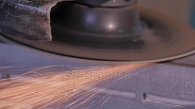 Disk öğütücü atölye ile metal testere ustası. Metal kıvılcım uçan taşlama. Çelik fabrika düşük hızlı çekim yapısında taşlama elektrikli tekerlekli. metal ile turuncu uçan taşlama