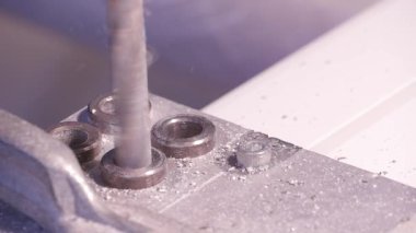 Alüminyum ve metal elektrikli matkap kullanarak delinmiştir delik. Alüminyum veya metal metal atölyesinde closeup elektrikli matkapla Delme. Yassı çelik plaka Delme tezgah matkap ile çalışan
