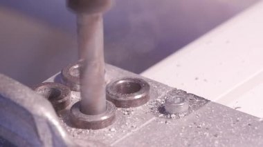 Alüminyum ve metal elektrikli matkap kullanarak delinmiştir delik. Alüminyum veya metal metal atölyesinde closeup elektrikli matkapla Delme. Yassı çelik plaka Delme tezgah matkap ile çalışan