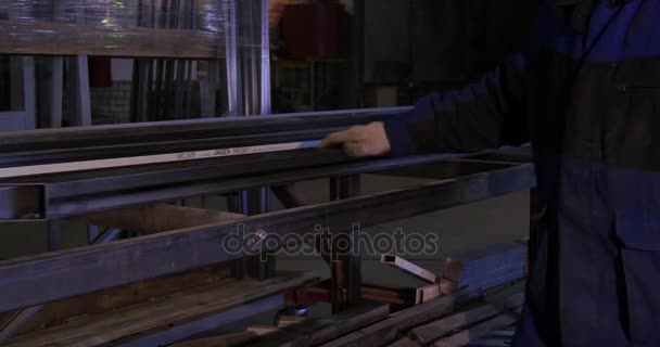 Laminatoio per lamiera di acciaio. Effetto spostamento inclinazione. Il lavoratore porta il profilo metallico alla macchina. Canale profilato metallico per l'utilizzo in strutture, magazzino. Acciaio su trasportatore. Le lastre sono — Video Stock