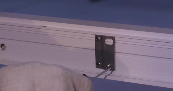 Operaio manuale che monta porte e finestre in PVC. Produzione di posti di lavoro. Concentrazione selettiva. Fabbrica di alluminio e PVC finestre e porte di produzione. Vite e dadi per mobili in lamiera forata. Lavoratori — Video Stock