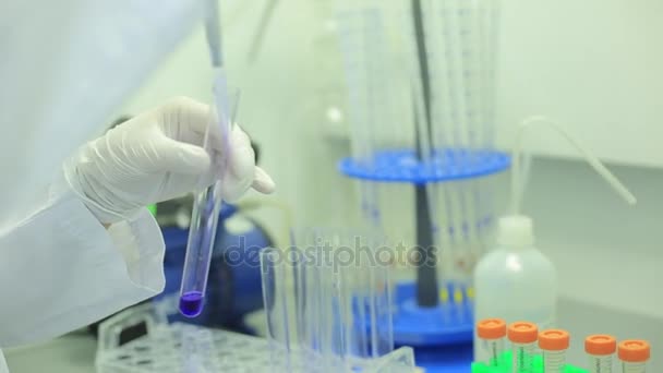 Fecho dos tubos de ensaio. Equipamento médico. Imagens de perto de um cientista usando uma micro pipeta em um laboratório. Técnico de laboratório injetando líquido em uma placa de microtitulação. Tubos de ensaio. Pequena profundidade de — Vídeo de Stock