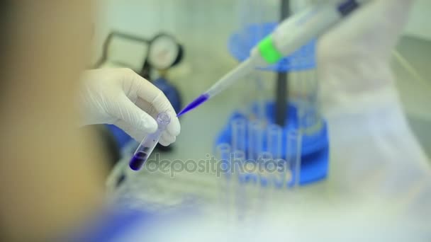 Fecho dos tubos de ensaio. Equipamento médico. Imagens de perto de um cientista usando uma micro pipeta em um laboratório. Técnico de laboratório injetando líquido em uma placa de microtitulação. Tubos de ensaio. Pequena profundidade de — Vídeo de Stock