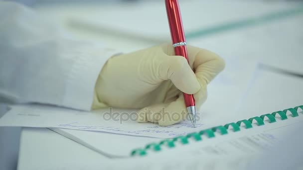 Sección media del médico escribiendo en papel en la clínica. Primer plano del paciente y del médico tomando notas. Doctor escribiendo una receta. Fisioterapeuta escribiendo en portapapeles en la clínica. doctora escribiendo un — Vídeos de Stock