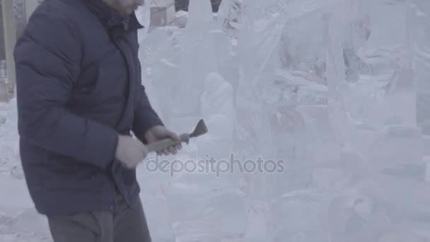 Schaber-Meister führt eine Bewegung über das Eis aus, um eine Eisskulptur zu schaffen. Meister mit speziellem Werkzeug zum Zerkleinern von Eisstücken. Eiskompositionen führen Kerben und Rillen im Stück von — Stockvideo