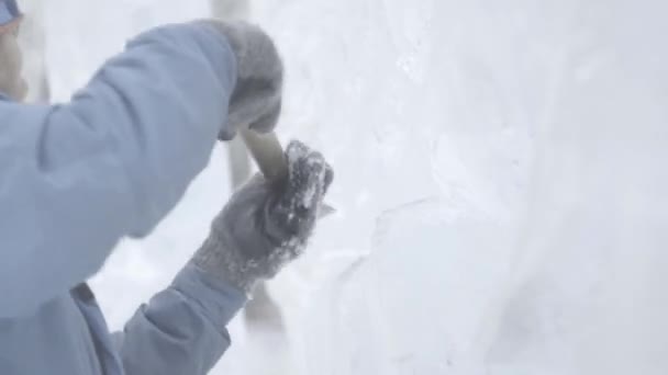 Master Scraper realiza um movimento através do gelo para criar uma escultura de gelo. Mestre usando ferramenta especial para moer peças de gelo formulário. Composições de gelo executa entalhes e sulcos na peça de — Vídeo de Stock