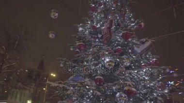 Güzel Noel ağacı parlayan parkın ortasında duruyor. Açık bir Noel ağacı ışıkları girdiği ile kesilmiş bir evin önünde. Noel dekorasyon arka plan ve Noel ağacı