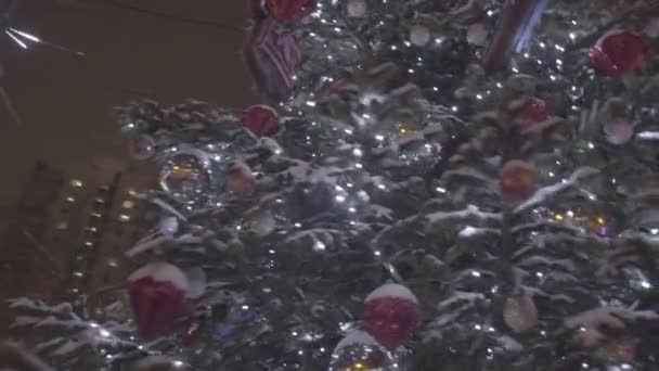 Bel arbre de Noël lumineux se dresse au milieu du parc .Un arbre de Noël en plein air en face d'une maison garnie de lumières entrant. Décoration de Noël fond et arbre de Noël 