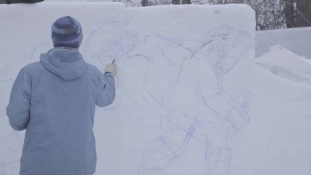 Tegner på sneen. Gør klar til at skære isen over. Vær forberedt på at begynde at lave isskulptur. For at male sneen. Tegn på sneen med farve. Tegn billeder på den hvide vintersne. V-LOG – Stock-video