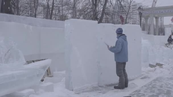 A desenhar na neve. Preparar para cortar o gelo. Esteja preparado para começar a fazer escultura de gelo. Para pintar a neve. Desenhe na neve usando a cor. Desenhe imagens na neve branca do inverno. V-LOG — Vídeo de Stock