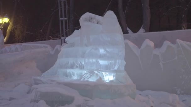Ледяная скульптура замороженного дракона в зимнем городе. Дракон из снега. Скульптуры льда в России. Скульптуры в ледяном городке. Ледяные скульптуры и водопады — стоковое видео