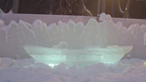 Eisskulptur aus gefrorenem Boot und Schiff in der Winterstadt. Skulptur von Boot oder Schiff aus Eis und Schnee. Eisskulpturen in Russland. Skulpturen in der Eisstadt. Eisskulptur und schöner Schneefall — Stockvideo