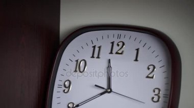 Beyaz duvar saati. Oval duvar saati 11:40 gösterir. Zaman