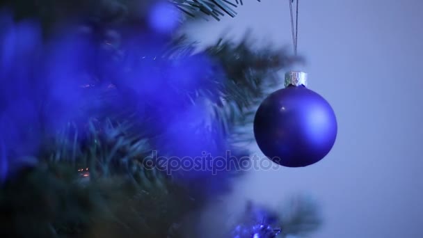 Silvesterspielzeug auf dem Weihnachtsbaum wie Schneeflocke und rote Kugel.Silvesterdekorationskugeln auf einem verschneiten Ast. Weiße Schneeflocke und blaue Weihnachtskugel. Selektiver Fokus