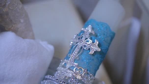 Bougie bleue décorative. Grande bougie décorative blanche avec croix sainte. La figure de la croix sur la bougie. Concentration sélective 