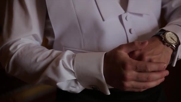 Pary młodej trzyma ręce na krawat, garnitur ślubny. zbliżenie dłoni człowieka jak nosi białą koszulę i spinki. Działalności człowieka mocowanie czarny krawat na białą koszulę. Krawat pana młodego na ślub dzień ustalenia, vintage — Wideo stockowe