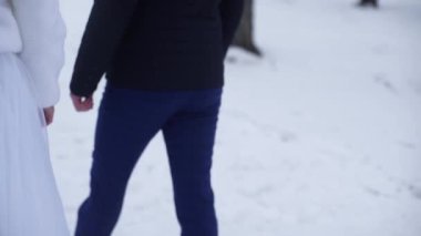 Dışında yürüme genç yeni evliler. Gelin ve damat birlikte kış veya yaz ve el ele parkta yürümek. mutlu gelin çift çalılar kiraz arasında parkta yürüyüş. Gelin ve damat