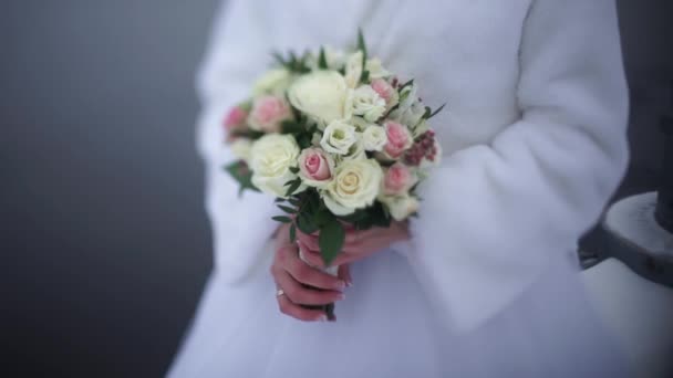 Noiva com flores na mão ao ar livre. A noiva está nervosa antes do casamento. Noiva a segurar um perfume. bouquet de casamento agradável na mão noivas. A noiva está segurando um lindo buquê de casamento brilhante. o — Vídeo de Stock