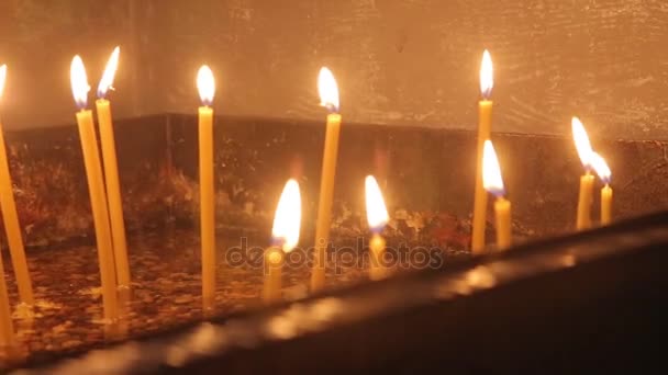 Encender una vela con una cerilla para conseguir una vela romántica. Increíbles andles y candelabros están sobre la mesa. Mantenga las luces con el trasfondo pacífico de la ceremonia religiosa . — Vídeo de stock