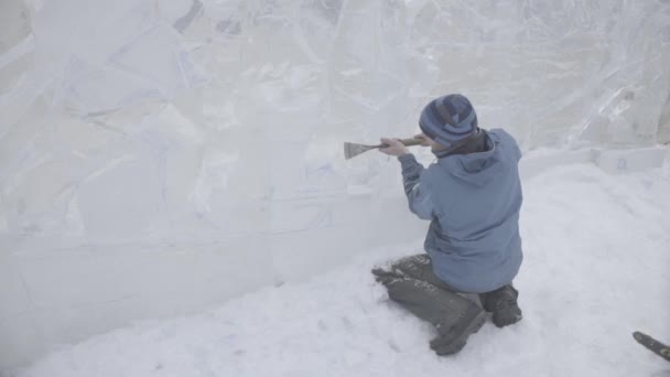El rascador maestro realiza un movimiento a través del hielo para crear una escultura de hielo. Maestro utilizando la herramienta especial para moler abajo forma piezas de hielo. Composiciones de hielo realiza muescas y surcos en el pedazo de — Vídeos de Stock