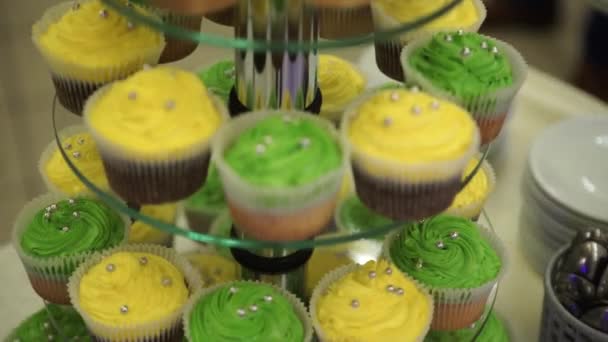 Cupcakes. Καταπληκτικά σοκολατένια κέικ και cupcakes. Σοκολάτα cupcake καραμέλα με καρύδια και σιρόπι καραμελέ. Πράσινο και κίτρινο cupcakes. Όμορφα cupcakes με χρωματιστά κρέμες. Επιλεκτική εστίαση. Bokeh — Αρχείο Βίντεο