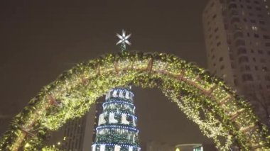 Çelenk gece kış Park'ta Ladin. Noel. Noel dekorasyon arka plan ve parlayan altın ışıkları ile Noel ağacı. Kış gecesi buz parkta. kar Köyü.