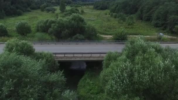 Letecký průzkum auta jezdí na hadí kmeny. Létání nad červený kabriolet jednotky na ulici. Letecký pohled na červené auto, které jede přes most. Provoz na mostě. Červené auto. — Stock video