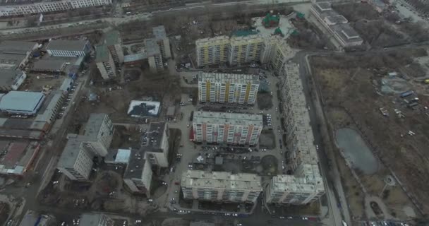 Aerial survey na miasto. Widok z nieba na rosyjskie miasto. Miasto z lotu ptaka widok na domy, ulice i parki. Szare niebo i garaże naprawdę mieszkaniowej dzielnicy. Aerial survey na ulicy gdzie jeździć dużo — Wideo stockowe