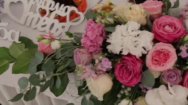 バラのウェディング ブーケ。結婚式の日の花嫁のブーケ。さまざまな花の花束。ドレッシング スツールに美しい白や赤とピンクのバラの花束。バラ — ストック動画