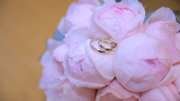 Trouwringen op een boeket van witte bloemen. trouwringen en boeket van donker blauwe bloem. Close-up. Bruiloft — Stockvideo
