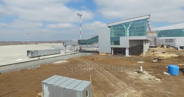 滑走路を持つ空港建設。空港の滑走路の眺めになる建設現場。労働者は、新しい空港と特別な装置を構築します。空港の建設と空の雲 — ストック動画