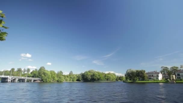 Het Paleis op de oever van de vijver in het park van Poesjkin in de buurt van Sint-Petersburg. oever van lake in Sint-Petersburg. Mooie Russische landschap met wilgen in de buurt van water van het meer en de wolken in de blauwe hemel — Stockvideo