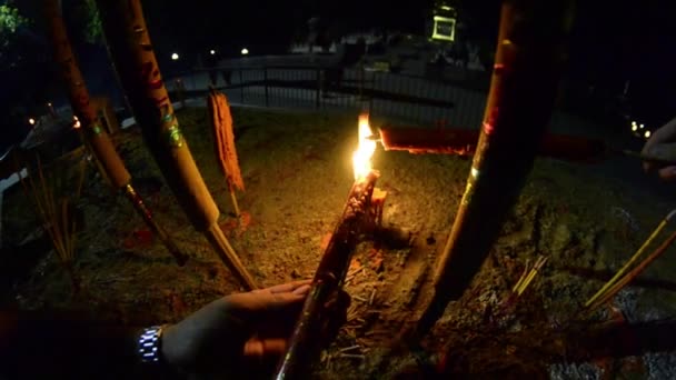 Burning candles in Buddhist temple at night. Mens hands on fire red large candles in the temple gopro. Red Candle in chinese temple. Fire first-person. Thai temple — Stock Video