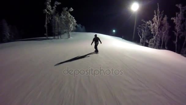 Homem snowboarder desliza para baixo da montanha na noite de inverno. o cara no snowboard está deslizando da montanha na noite gopro. Snowboarder esqui em altas montanhas gopro. primeira pessoa — Vídeo de Stock