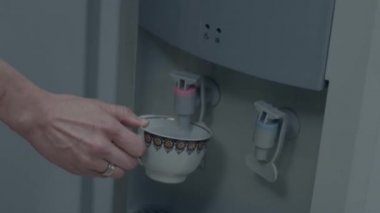 Su, su soğutucu cam Kupası'nda hizmet veren el. Su soğutucu döktü. İçme suyu soğutucusu dökülür. Office