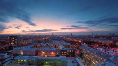 Akşam şehirde kış timelapse. Çatı timelapse görünümünden kış şehirde akşam. Panoramik şehir ve çatılar timelapse kar altında. Sokak gece şehir ışıkları
