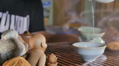 Geleneksel Çince çay töreni ve kil bir bardak çay dökün. Kepçe yardımıyla dökme çay
