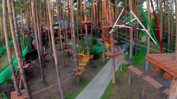 Parque de cordas no parque - nó de corda. curso de cordas altas na floresta. aventura escalada alto fio parque - pessoas em curso em capacete de montanha e equipamentos de segurança. Parque com cordas — Vídeo de Stock