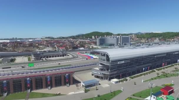 De Formule 1 track in Sotsji, het Olympisch dorp in Sotsji. Bouwplaats van stadion voor racen in de buurt van de stad en de bergen, op zonnige zomerdag. Luchtfoto. Aerrial uitzicht op de pectator staat Russische F1 — Stockvideo