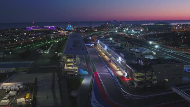 Aerial OLIMPIC VILAGE, SOCHI, RUSSIA. The Olympic village in Sochi at night. Amazing perspective of fantastic Bogatyr hotel, the formula 1 track, the stadium fischt, building backlighted by different — Stock Video