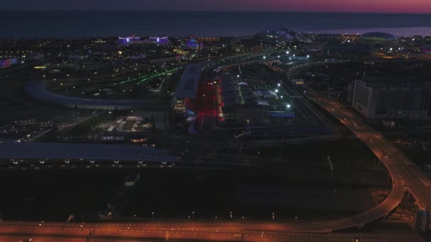 Antenne olimpic vilage, Sotschi, Russland. Das olympische Dorf in Sotschi in der Nacht. Traumhafte Aussicht auf das fantastische Bogatyr-Hotel, die Formel-1-Strecke, das Stadion, Gebäude, das von verschiedenen — Stockvideo