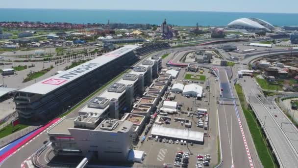 La pista di formula 1 a Sochi, il villaggio olimpico di Sochi. Cantiere dello stadio per correre vicino alla città e le montagne in estate giornata di sole. Vista aerea. Vista guerriera su pettorali stand F1 russo — Video Stock