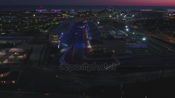 Aerial OLIMPIC VILAGE, SOCHI, RUSSIA. The Olympic village in Sochi at night. Amazing perspective of fantastic Bogatyr hotel, the formula 1 track, the stadium fischt, building backlighted by different — Stock Video
