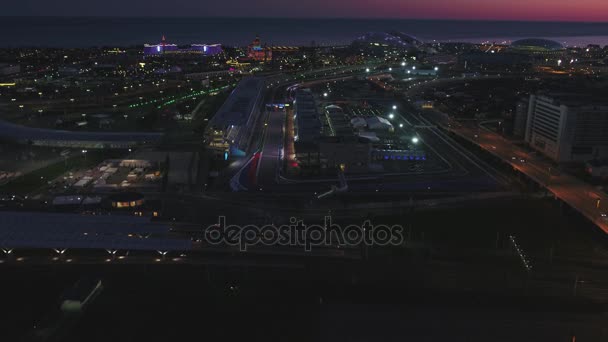 Luchtfoto Olimpic dorp, Sochi, Rusland. Het Olympisch dorp in Sotsji 's nachts. Geweldig perspectief van fantastische Bogatyr hotel het Formule 1 circuit, het stadion fischt, gebouw verlichting door verschillende — Stockvideo