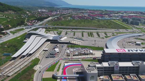 Toru Formuły 1 w Soczi, wioski olimpijskiej w Soczi. Plac budowy stadionu do wyścigów w pobliżu miasta i gór w słoneczny letni dzień. Widok z lotu ptaka. Aerrial widok na pectator stoi rosyjski F1 — Wideo stockowe