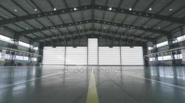 Silindir Panjur kapı ve fabrika binası için endüstriyel arka plan içinde beton zemin. Uçak ön yarısı hangar kapısını açtım. Hangara açık kapı. Kapı açma makinist