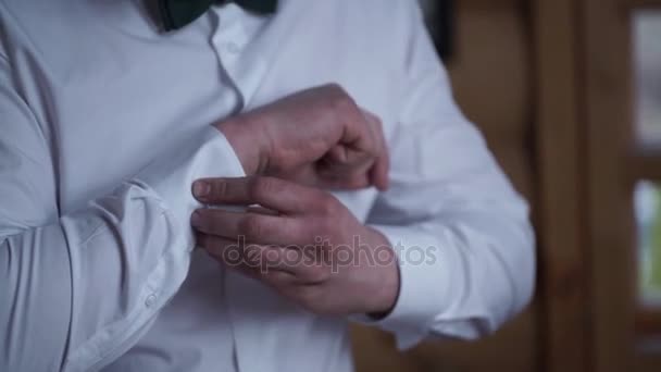 Мужчина застегивает рукава рубашки. Крупным планом рука человека, как носит белую рубашку и запонку. Мужчина застегивает рубашку на рукаве. Застегни запонку. Менс . — стоковое видео