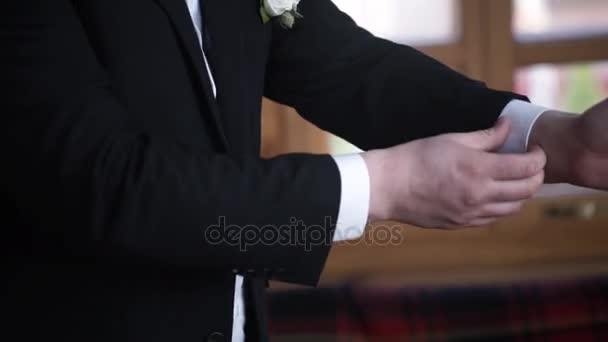 Man buttoning on a black jacket. Wedding details - elegant groom dressed wedding tuxedo costume is waiting for the bride. businessman buttoning jacket, getting dressed. Groom buttons jacket — Stock Video
