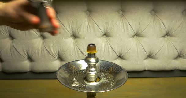 Fumar narguilé em um fundo preto com uma bela fumaça. Tigela de narguilé marrom para tabaco com perna longa. Preparando a shisha, aka nargile ou narguilé em um restaurante, colocando os carvões no topo . — Vídeo de Stock