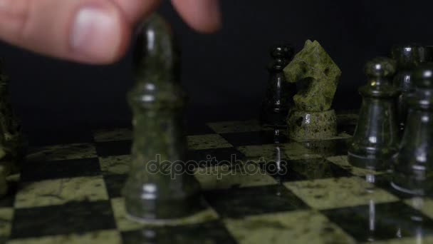 O elefante negro no xadrez derrota o cavalo branco. Detalhe da peça de xadrez sobre fundo preto. Jogo de xadrez. vista de perto. Foco seletivo — Vídeo de Stock